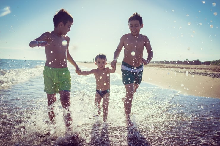 Fun kids playing splash at beach.jpeg