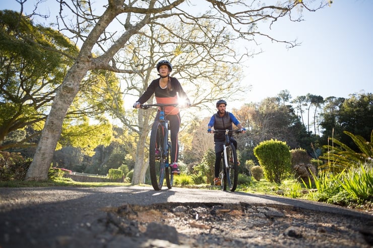 Smiling biker couple cycling on the countryside road.jpeg