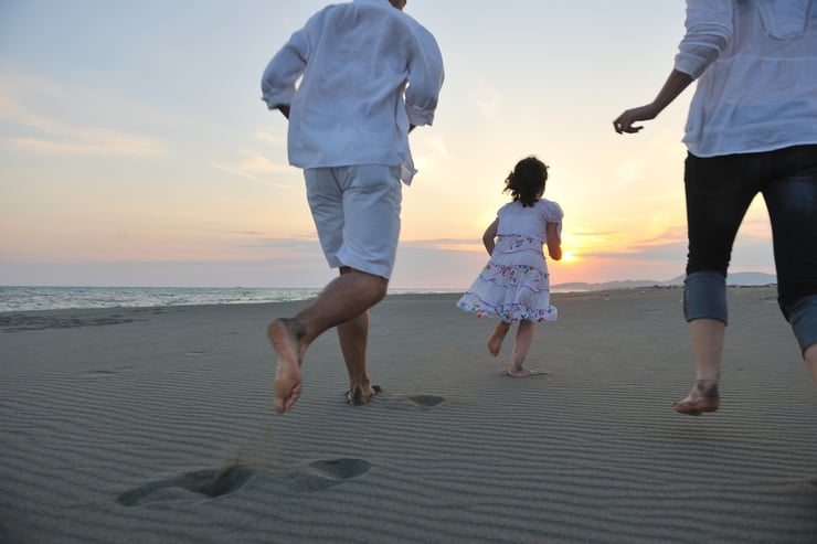 happy young family have fun on beach run and jump  at sunset.jpeg